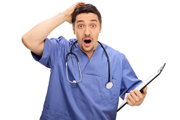 Surpreendido jovem médico de uniforme azul — Fotografia de Stock