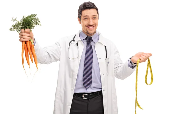 Cheerful doctor holding a bunch of carrots — Stock Photo, Image