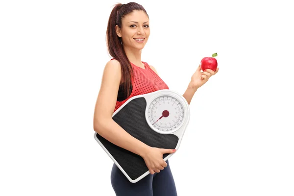 Женщина держит яблоко и весы — стоковое фото