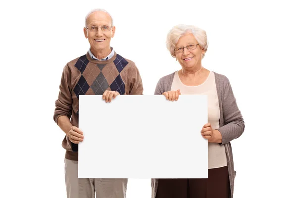 Senior paar poseren met een uithangbord — Stockfoto