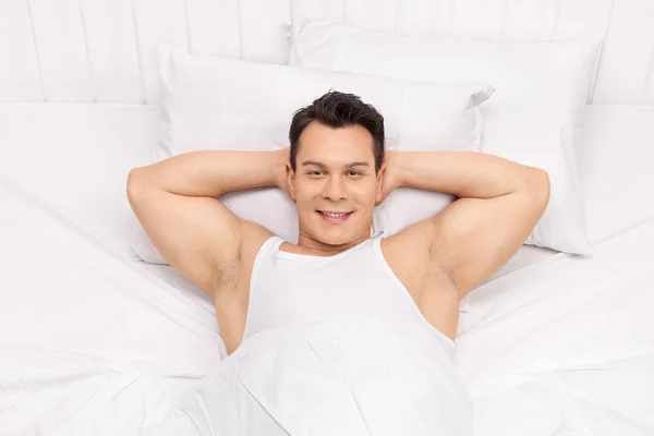 Веселый человек, лежащий на кровати — стоковое фото