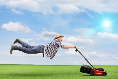 Olgun adam bir çim biçme makinesi tarafından varlık makara