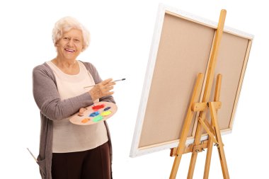 Senior lady posing next to a canvas  clipart