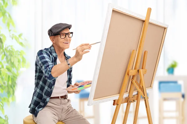 Homem idoso desenhando em uma tela em casa — Fotografia de Stock