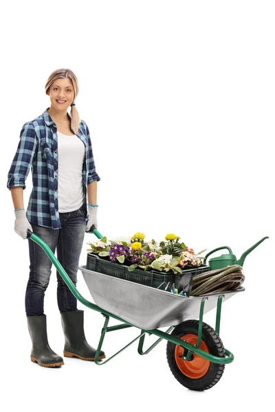 Vrouwelijke tuinman duwen een kruiwagen — Stockfoto