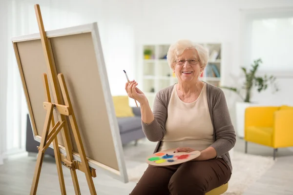 Femme âgée peignant sur une toile — Photo