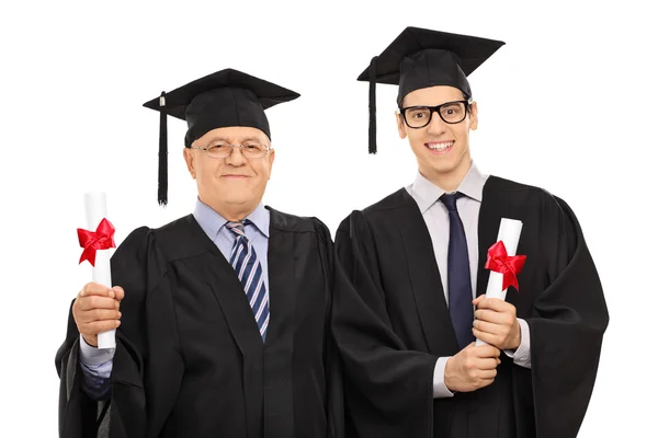 Zralé a mladých mužů pózuje s diplomy — Stock fotografie