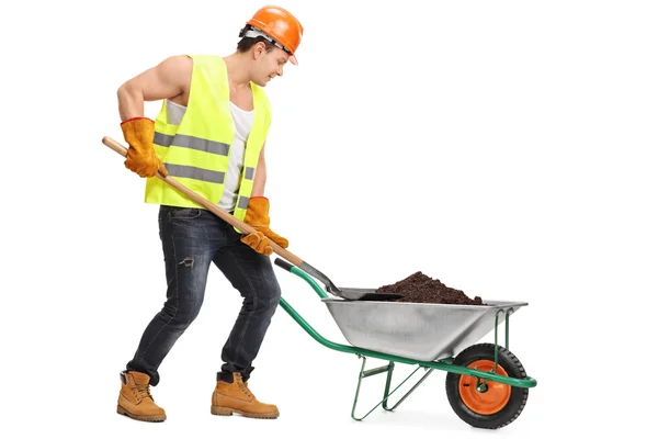 Worker in smuts i en skottkärra — Stockfoto