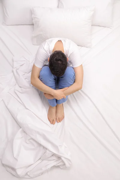 Hombre deprimido sentado en una cama — Foto de Stock