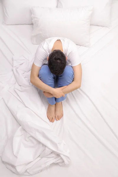 Homme déprimé assis sur un lit — Photo