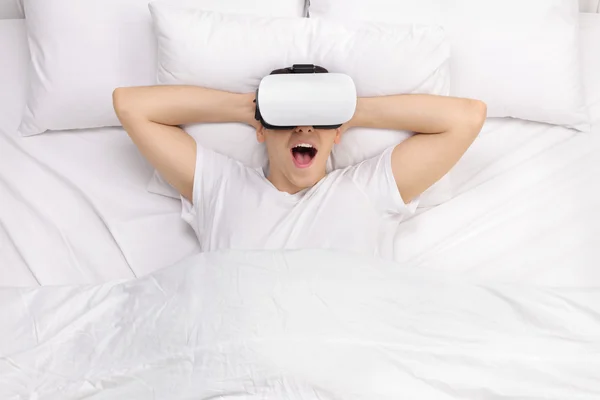 Bărbat pe pat folosind ochelari VR — Fotografie, imagine de stoc