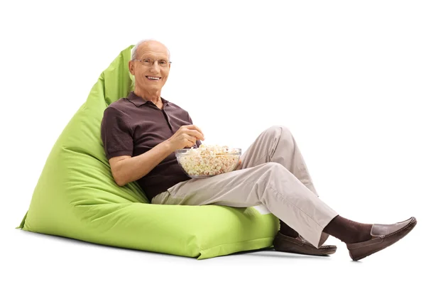 Senior man eating popcorn — Stock Photo, Image