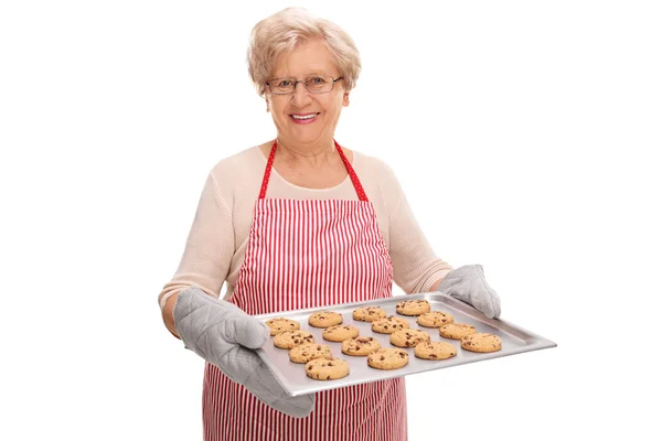 Señora madura sosteniendo una bandeja con galletas — Foto de Stock