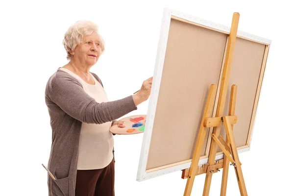 Senior vrouw schilderen op een doek — Stockfoto