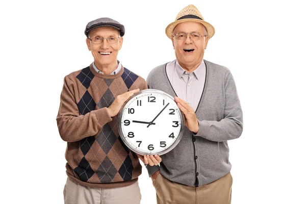 Two elderly men holding a big clock — Stock Photo, Image