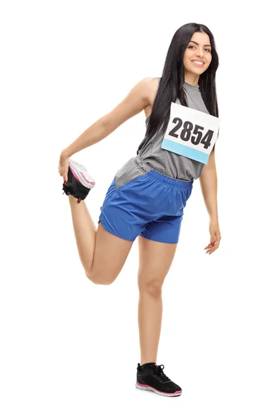 Kvinnliga löpare stretching hennes ben — Stockfoto