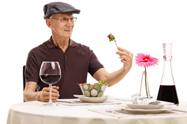 Uomo anziano che guarda un'insalata disgustata — Foto Stock