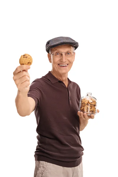 Senior man die een kruik met cookies — Stockfoto