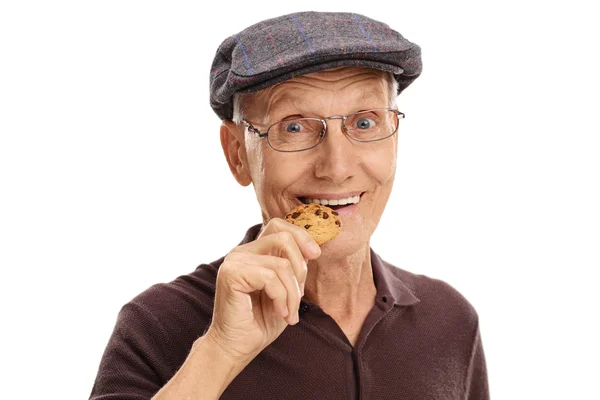 Hombre maduro comiendo una galleta de chocolate — Foto de Stock