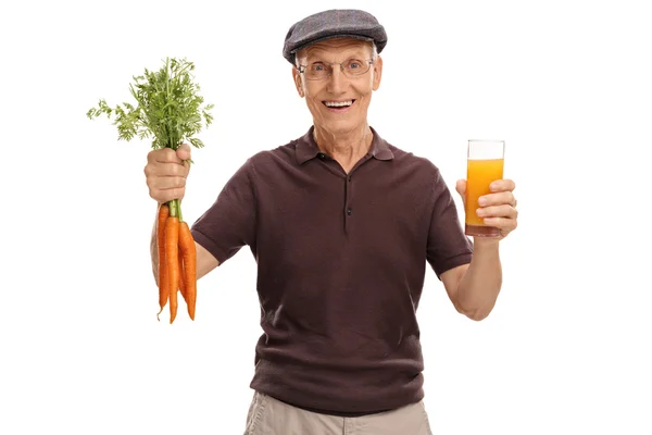 Uomo anziano con bicchiere di succo e carote — Foto Stock