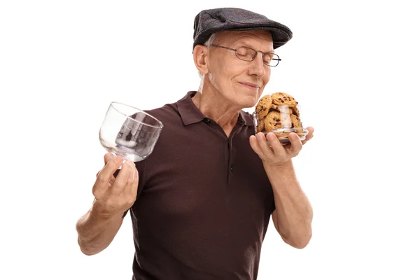 Senior gentleman opening a jar of cookies and smelling — Stock Photo, Image