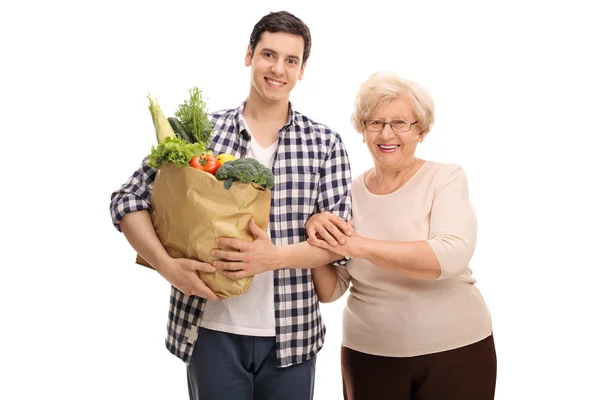 Man helping his grandmother with groceries — Stock Photo, Image