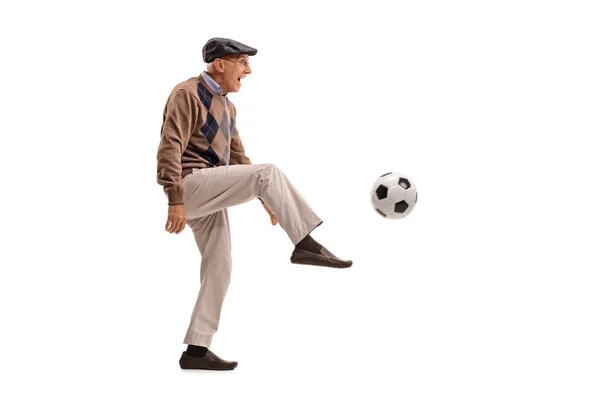 Joyful senior man chutando uma bola de futebol — Fotografia de Stock