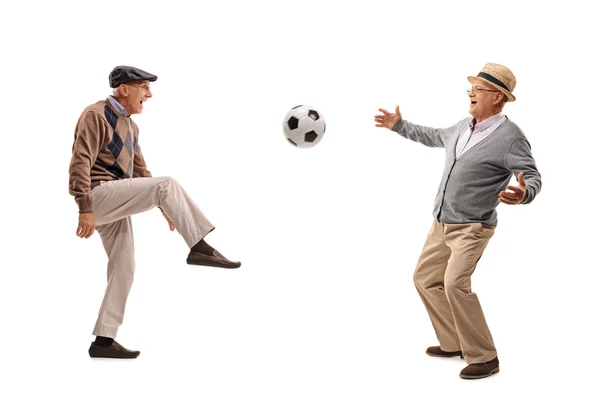 Homens seniores alegres que passam uma bola de futebol — Fotografia de Stock
