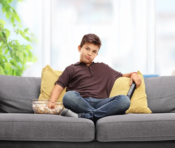 Bored kid eating popcorn — Stock Photo, Image