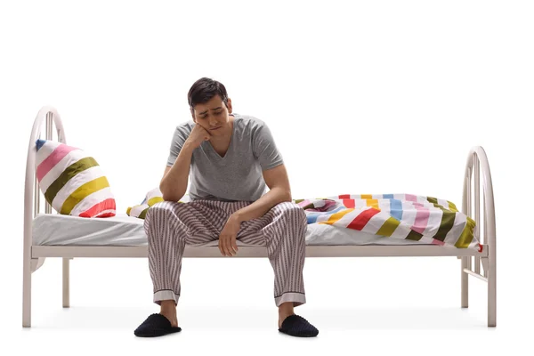 Depressiver junger Mann sitzt auf einem Bett — Stockfoto