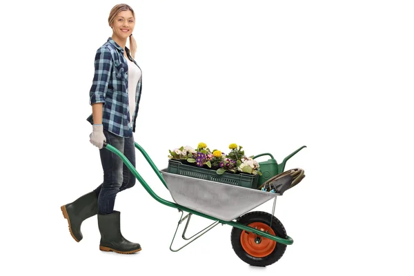 Vrouw duwen een kruiwagen met bloemen — Stockfoto