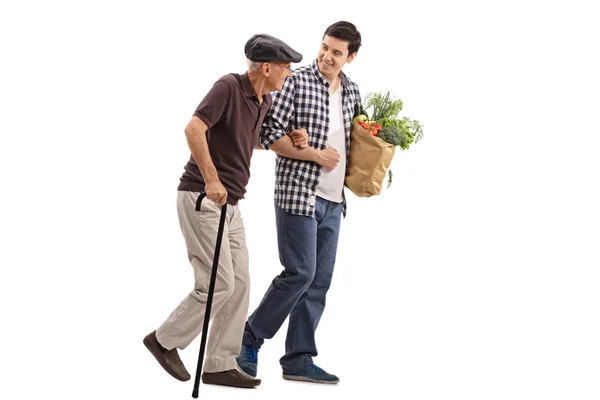 Un uomo gentile che aiuta un signore anziano con la spesa — Foto Stock