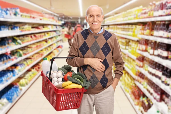 Senior man winkelen in een supermarkt — Stockfoto