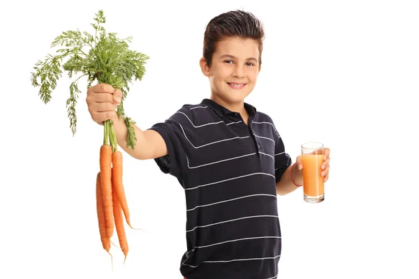 Ragazzo che tiene le carote e un bicchiere di succo — Foto Stock