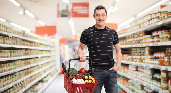 Chico alegre de compras en un supermercado — Foto de Stock