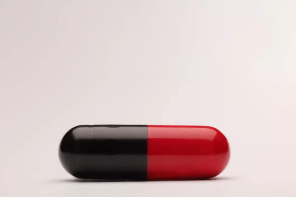 Pilule médicale rouge et noire — Photo