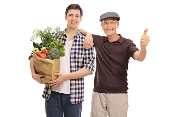 Guy een senior man helpen met boodschappen — Stockfoto