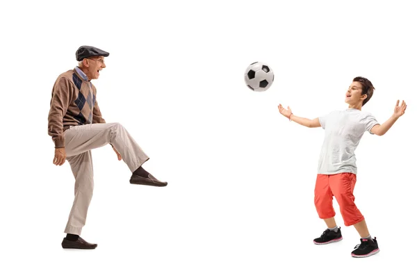 Homem sênior e uma criança passando por uma bola de futebol — Fotografia de Stock