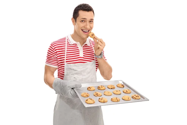 Homem alegre comendo biscoitos — Fotografia de Stock