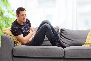 Genç adam yaşayan mide ağrısı