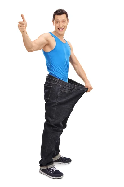 Mannen i överdimensionerade jeans ger tummen upp — Stockfoto