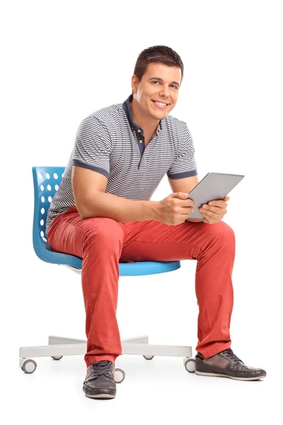 Man håller en tablett som sitter på en stol — Stockfoto