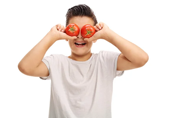 Kid holding tomatoes on his eyes — Stock Photo, Image