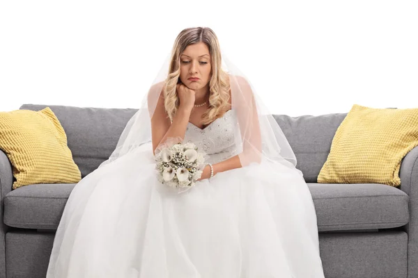 Worried young bride sitting on a sofa — Stock Photo, Image