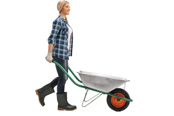 Female worker pushing a wheelbarrow — Stock Photo, Image