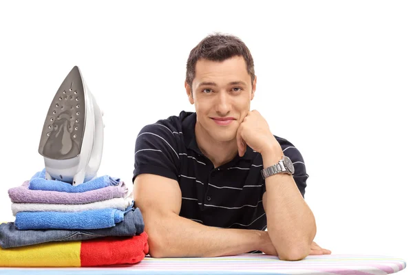 Guy posing behind an ironing board — Stock Photo, Image