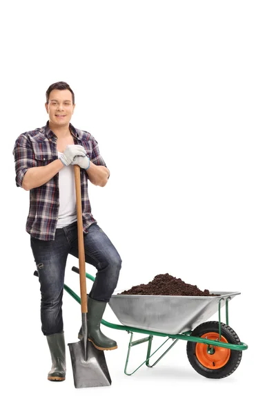 Man poseren door een kruiwagen met vuil — Stockfoto
