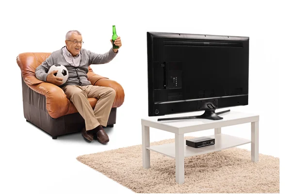 テレビでサッカーを見ている中年の男性 — ストック写真