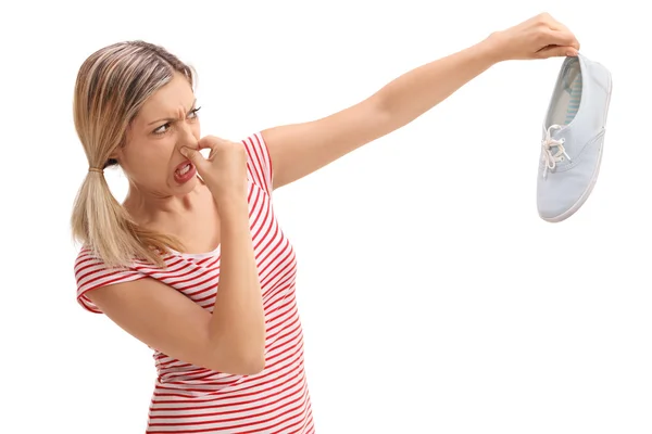 Mulher loira segurando um sapato fedorento — Fotografia de Stock