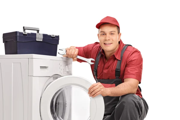 Repairman posing by a washing machine — Stock Photo, Image